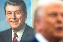 Photo of Donald Trump in front of a painting of Ronald Reagan.