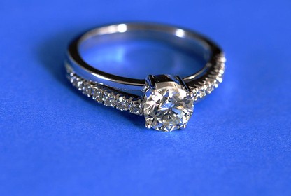 A diamond engagement ring on a blue background