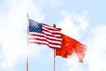 The U.S. and Chinese flags fly amid clouds.