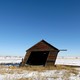 tilted wooden shack against blue sky