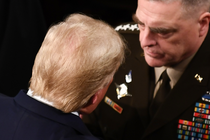 The back of Trump's head as he converses with General Mark Milley