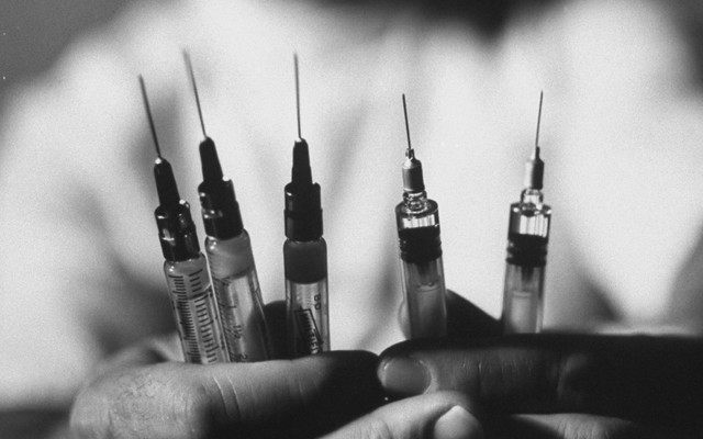 A man holding syringes