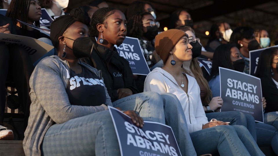 A photo of young people holding signs supporting Stacey Abrams