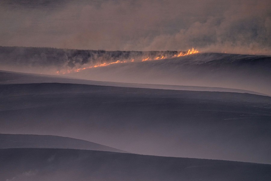 A view of a fire burning across pasture land