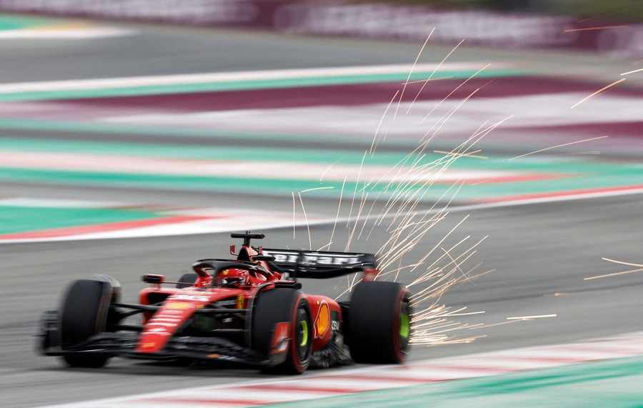 A race car throws sparks as it speeds down a track.