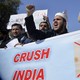 Pakistani men attend a rally with a banner that shows Indian Prime Minister Narendra Modi's face crossed out.
