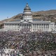 A large crowd of protesters gathers outside a state capitol building.