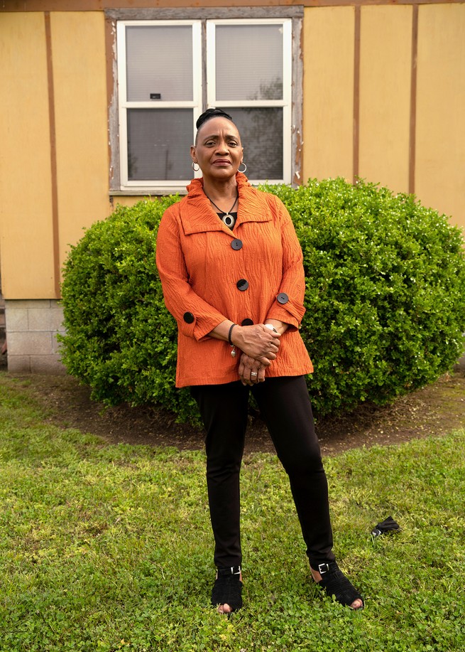 Brenda in orange in front of her home