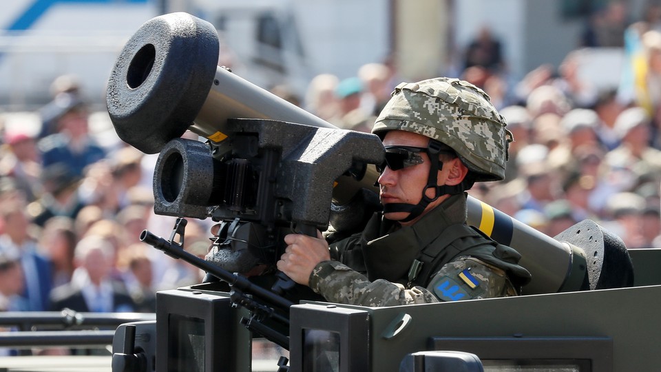 A Ukrainian army service member rides in an armored vehicle with a Javelin anti-tank missile during a parade to celebrate Ukraine's independence.