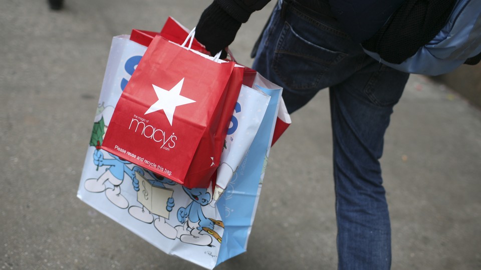 A photo of the lower half of a person with shopping bags in hand