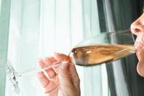 An image of a woman drinking a glass of champagne.