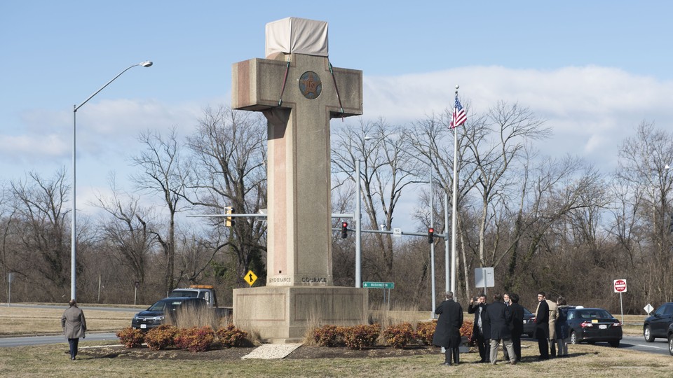 Visitors walk around the 40-foot Maryland Peace Cross in 2019