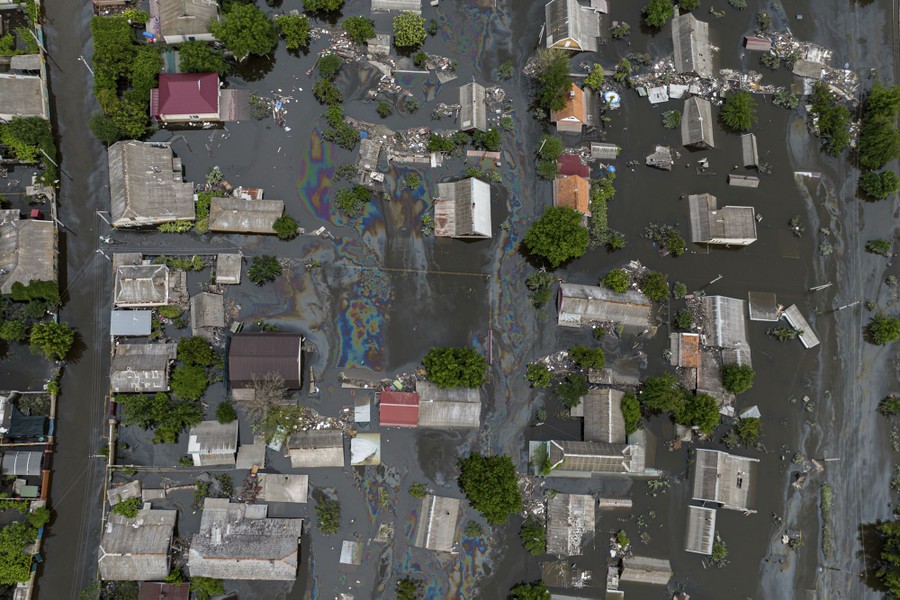An aerial view of a flooded neighborhood with many oil slicks visible