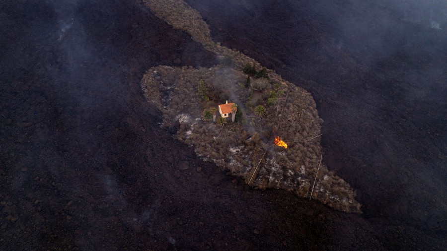 A drone view of a lone house, surrounded by lava, but spared from destruction