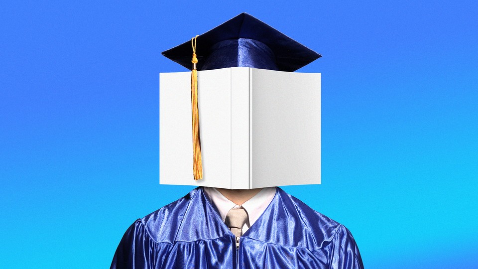 A graduate in cap and gown with a book covering their face
