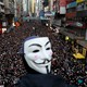 A protester wearing a Guy Fawkes mask heads a demonstration in downtown Hong Kong.
