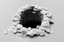 A black-and-white photo-illustration of sets of white paper packets, resembling printed research papers, stacked in a circle with a hole in the center plummeting into darkness.