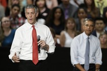 Duncan speaking into a microphone with Obama behind him