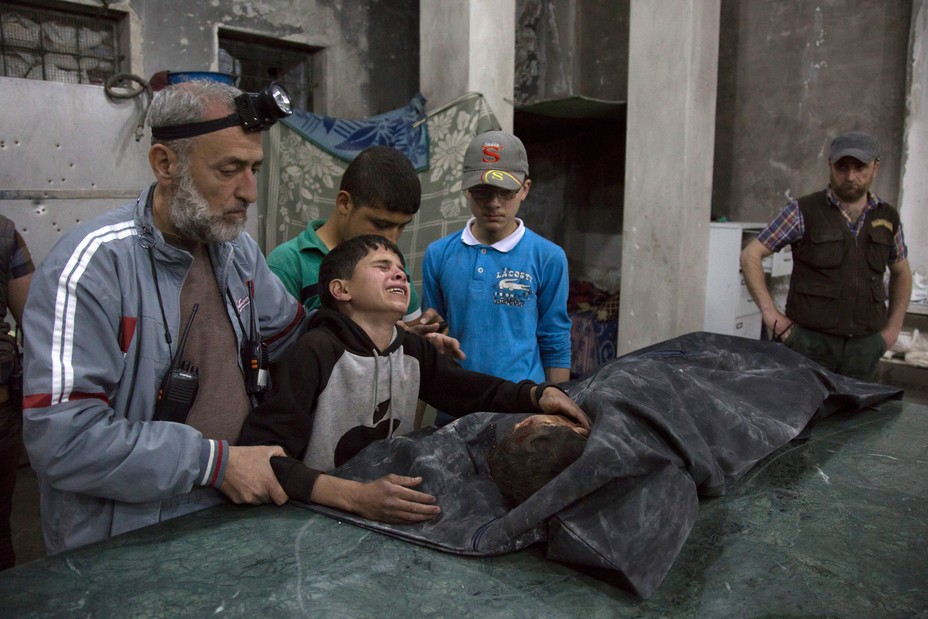 A Syrian boy is comforted as he cries next to the body of a relative who died in a reported airstrike on April 27, 2016 in the rebel-held neighbourhood of al-Soukour in the northern city of Aleppo. 