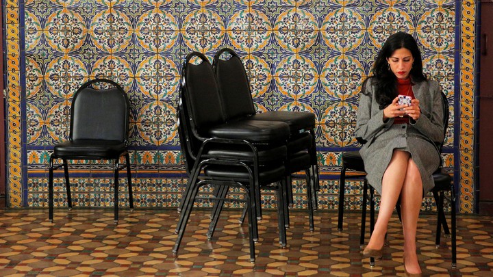 Huma Abedin checking her phone at a campaign stop