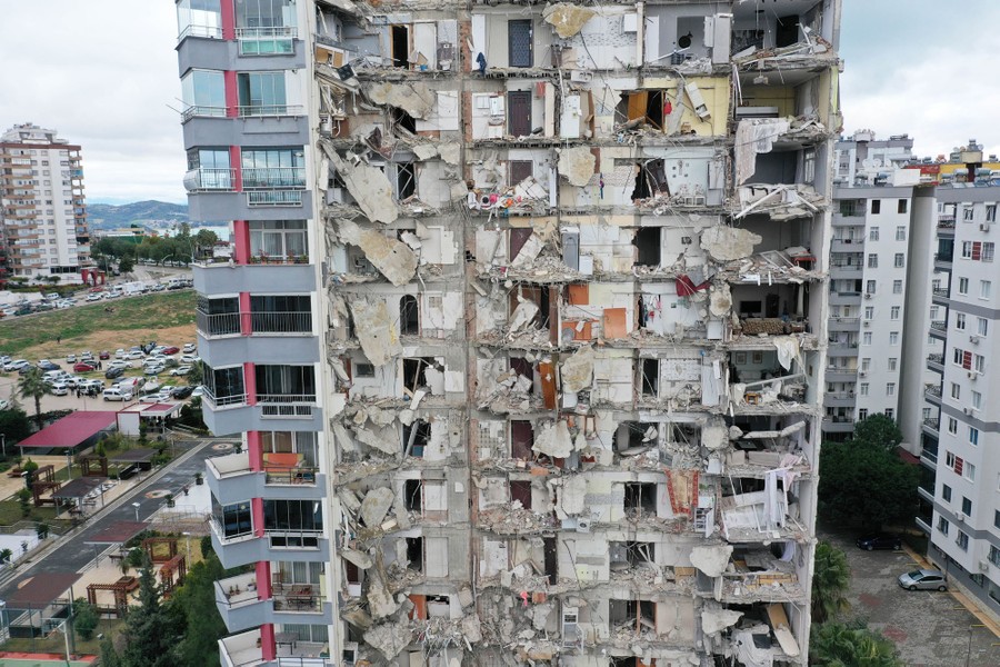 A damaged apartment building, with half of it fallen away, exposing the interior