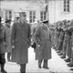 Winston Churchill and General De Gaulle walk past assembled French soldiers under a snowstorm.