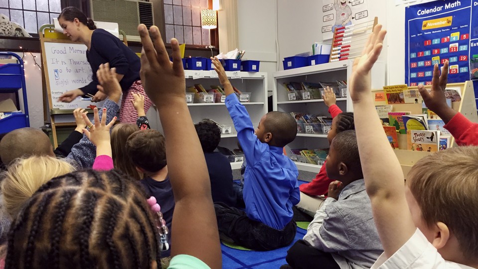 Kids, both black and white, raise their hand at Detroit Prep, an intentionally diverse school.