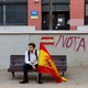 A man holding a Spanish flag sits on a bench before a pro-union demonstration organized by the Catalan Civil Society in Barcelona, Spain on October 8, 2017.