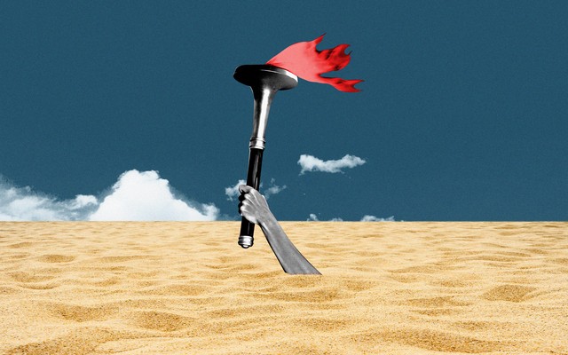 A hand bearing the olympic torch sinks beneath the sands
