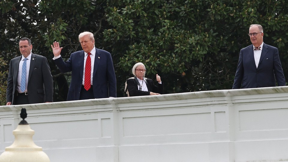 Donald Trump waving from a roof