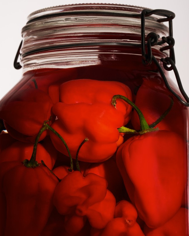 A closeup photograph of a jar of brining pickles