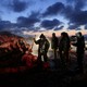 A group of people butcher a bowhead whale on a beach.