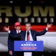 Donald Trump stands behind Mehmet Oz as Oz speaks at a podium