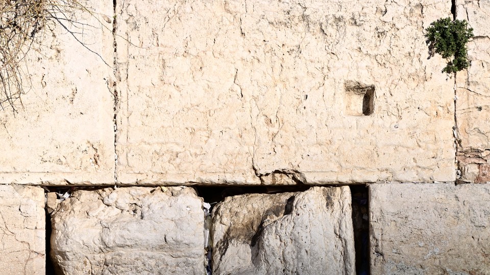 A man bows his head at the Western Wall.