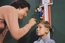 A mother measuring the height of her child.