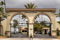 A pedestrian walks past the entrance to Paramount Pictures on Melrose Avenue in Los Angeles.