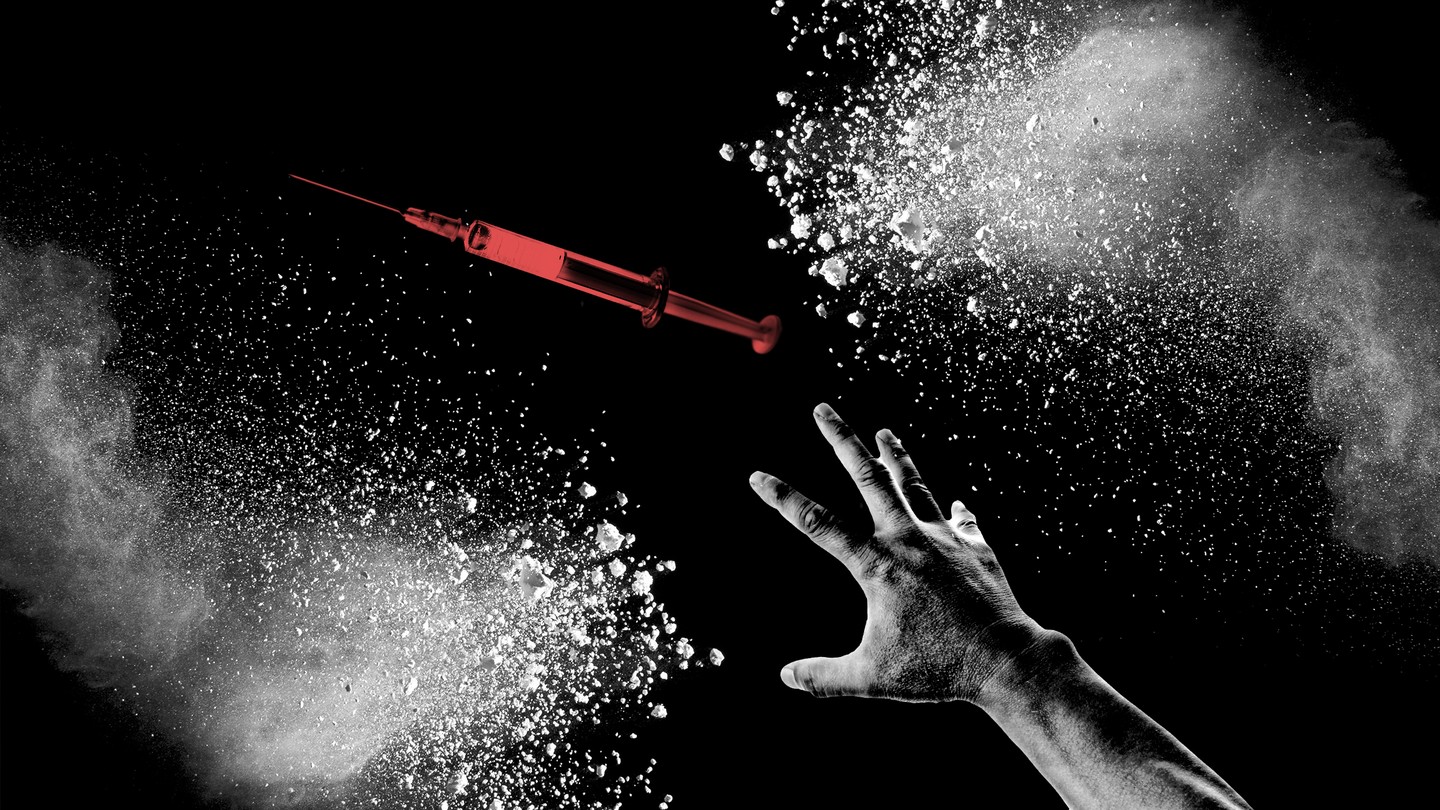 A hand reaching for a needle among white powder