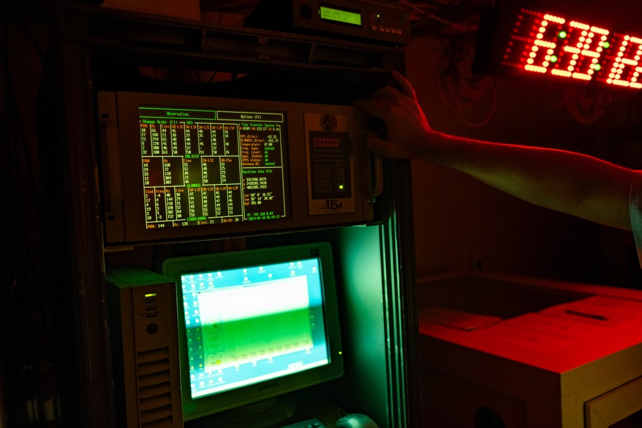 A transmitter and computer are light up in dark room.