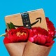A graphic illustration of an Amazon box sitting in a bouquet of red flowers