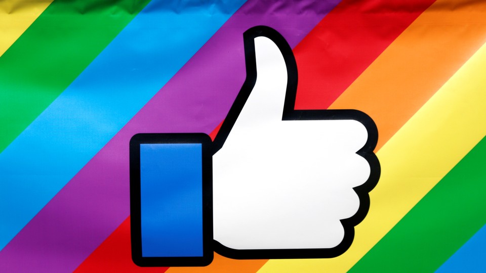The Facebook thumbs-up logo is displayed on a rainbow-colored banner during the annual Pride parade in New York City, in 2016.