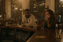 A still from the Apple TV+ series 'Slow Horses' showing two characters sitting at a bar