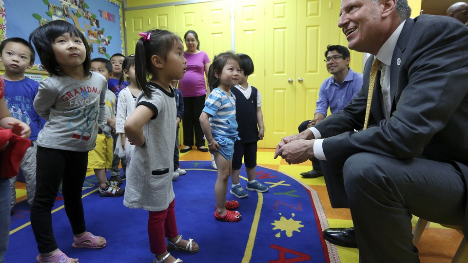 New York City Mayor Bill de Blasio smiles at children in a pre-k classroom in Brooklyn.