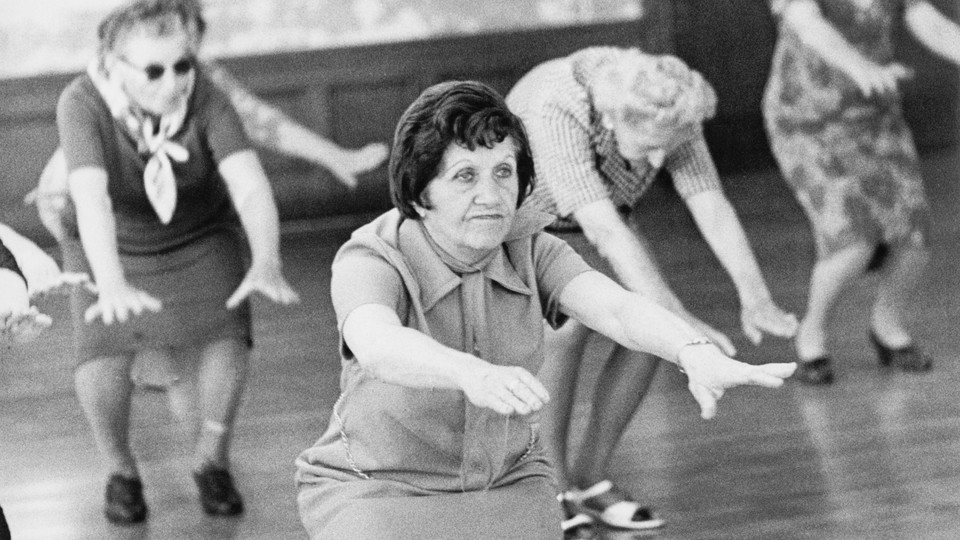 B&W photo of older women exercising in a large room