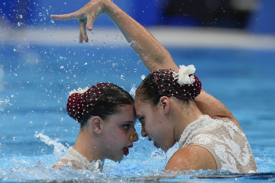 Artistic swimmers perform a duet.