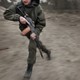 blurry image of a man running with a gun in combat gear