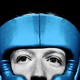 Black-and-white close-up photo of Mark Zuckerberg wearing blue sparring headgear