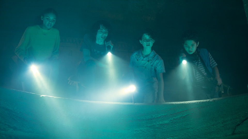 A still from Ghostbusters showing four kids holding flashlights in a blue fog