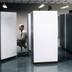 An office worker at a cubicle. He looks bored.