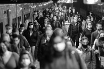 A black-and-white photo of commuters leaving a train in a station in New York City