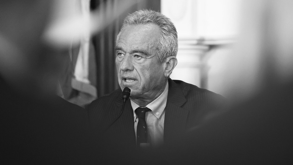a black and white photograph of Robert F. Kennedy Jr. speaking into a microphone